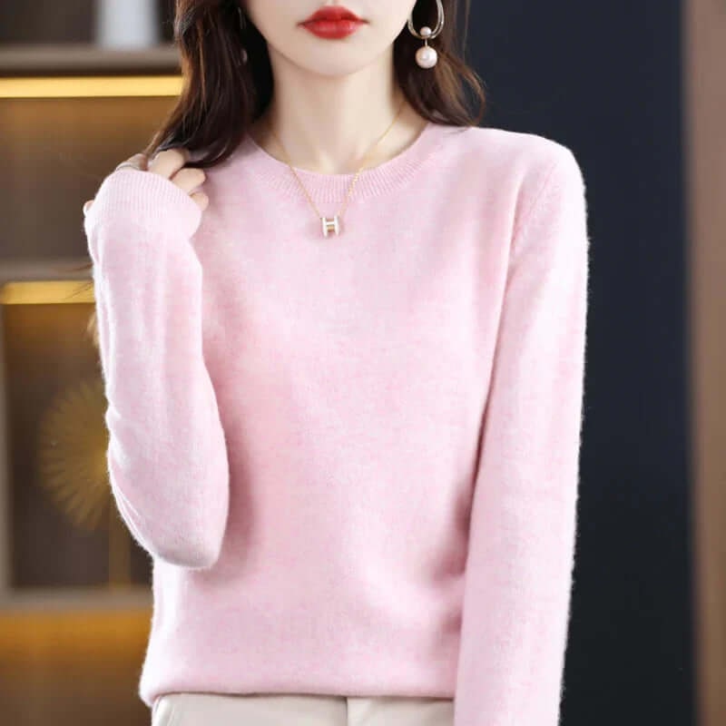 A model wearing a pink long-sleeved crew neck sweater.