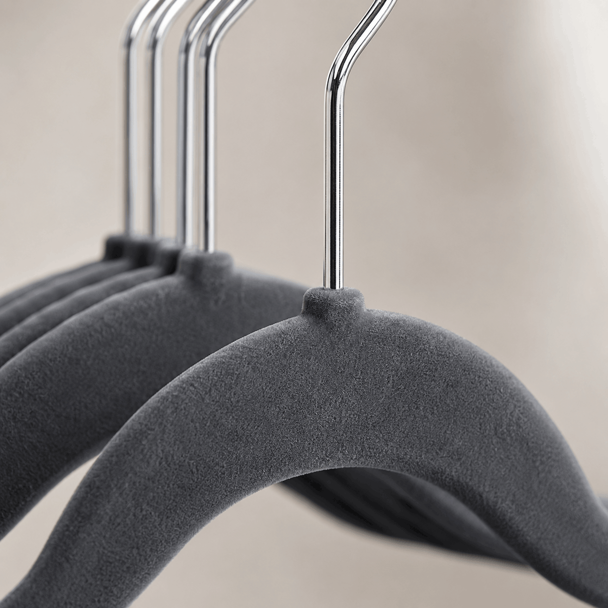 Close-up of charcoal grey velvet hanger texture and polished chrome hook