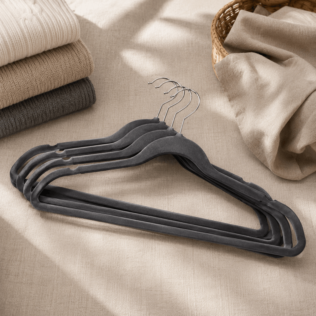 Velvet clothes hangers displayed with folded clothing in a wardrobe organisation setting