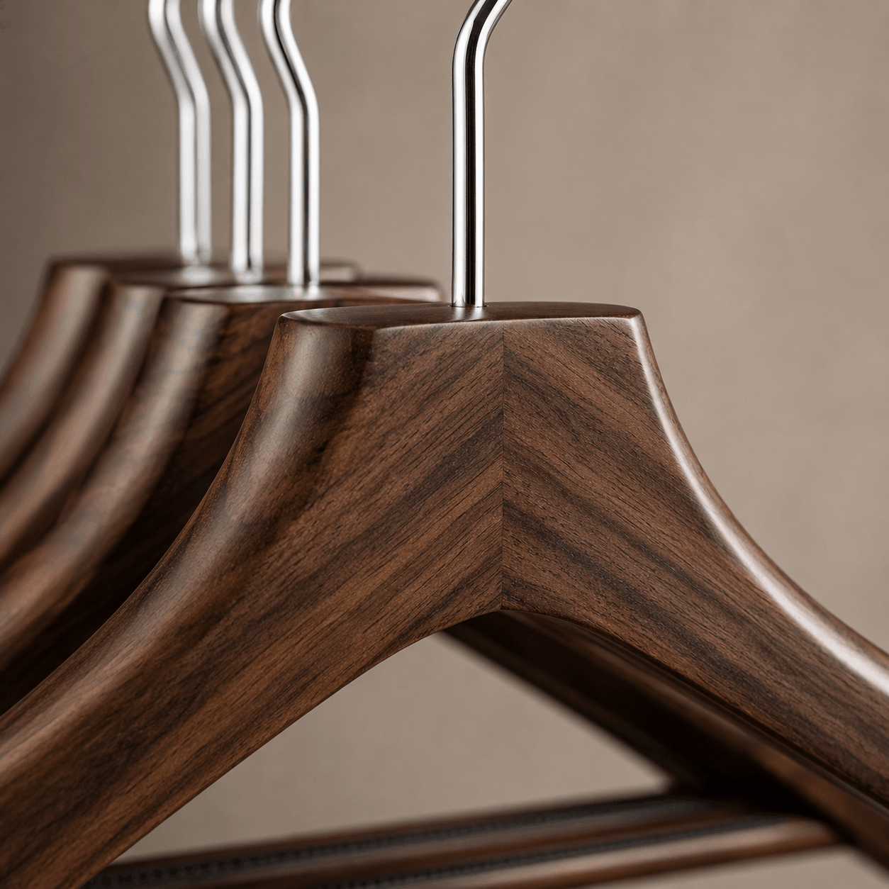 Close-up view of walnut wood grain texture and polished chrome hanger hook