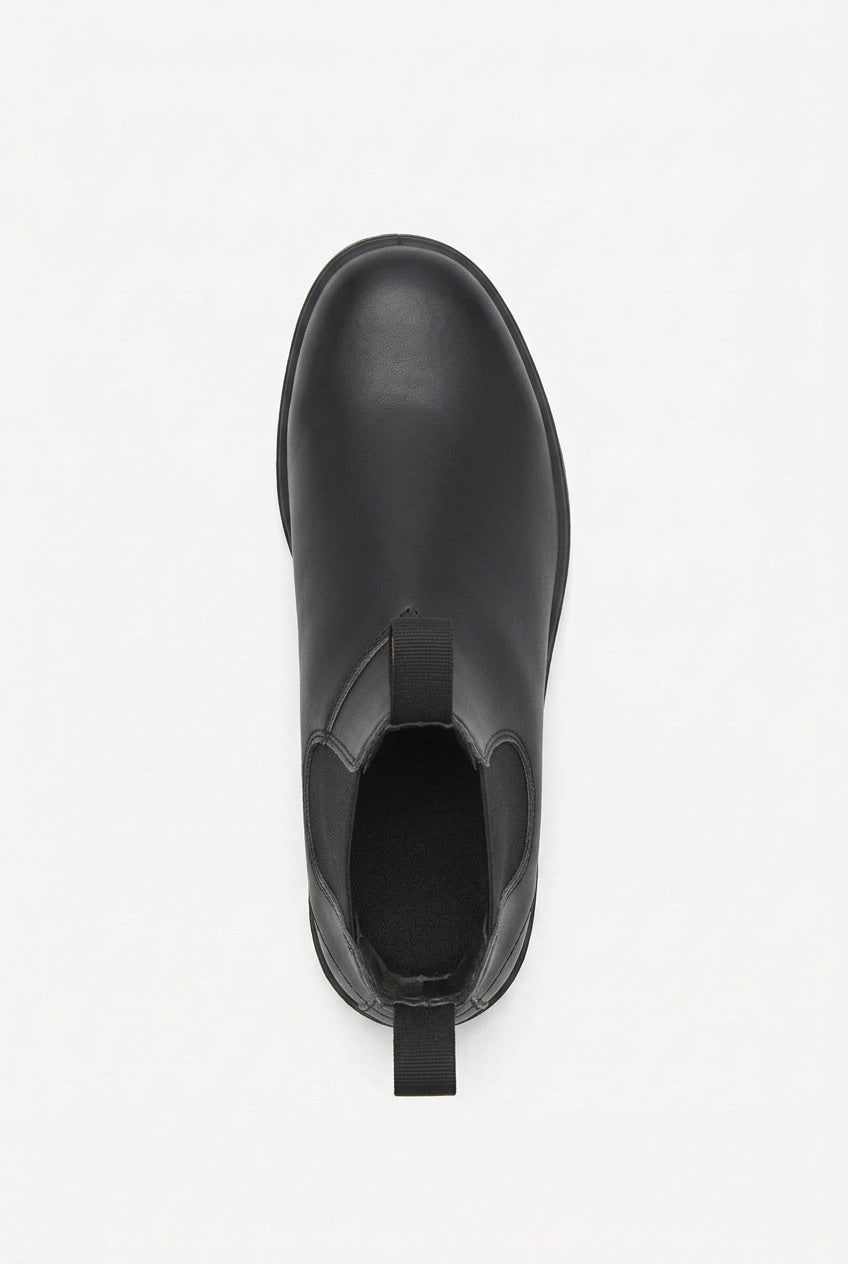 A single black leather Chelsea boot is shown from a top-down perspective on a white background.
