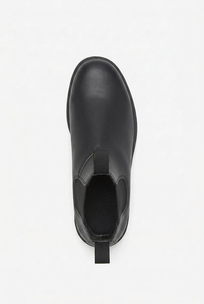 A single black leather Chelsea boot is shown from a top-down perspective on a white background.