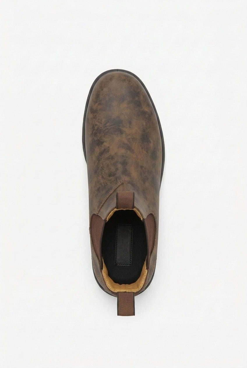 A single distressed brown leather Chelsea boot is shown from a top-down perspective on a white background.