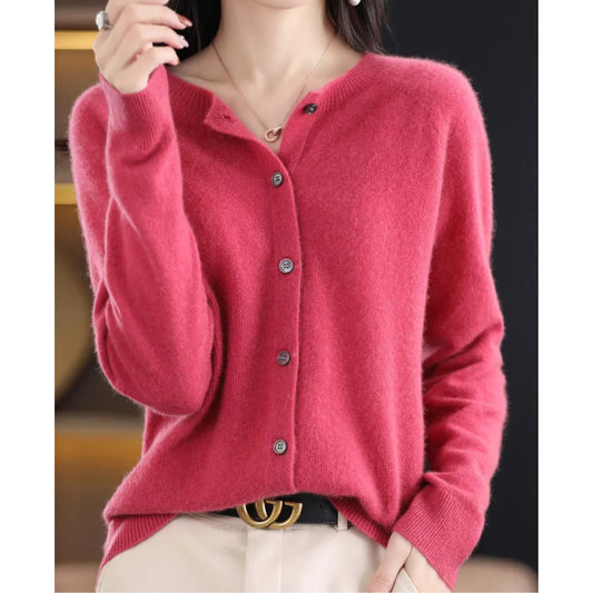 Front view of a woman wearing a pink fine knit button-front cardigan, styled with the top button undone.