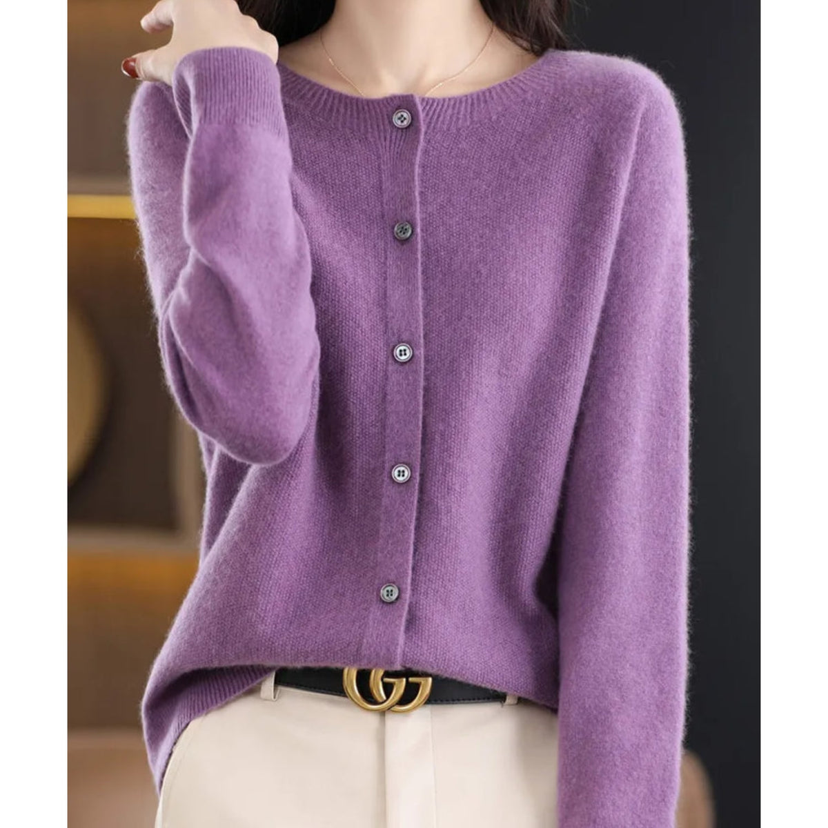 A model wears a purple button-up cardigan with a gold GG belt buckle.
