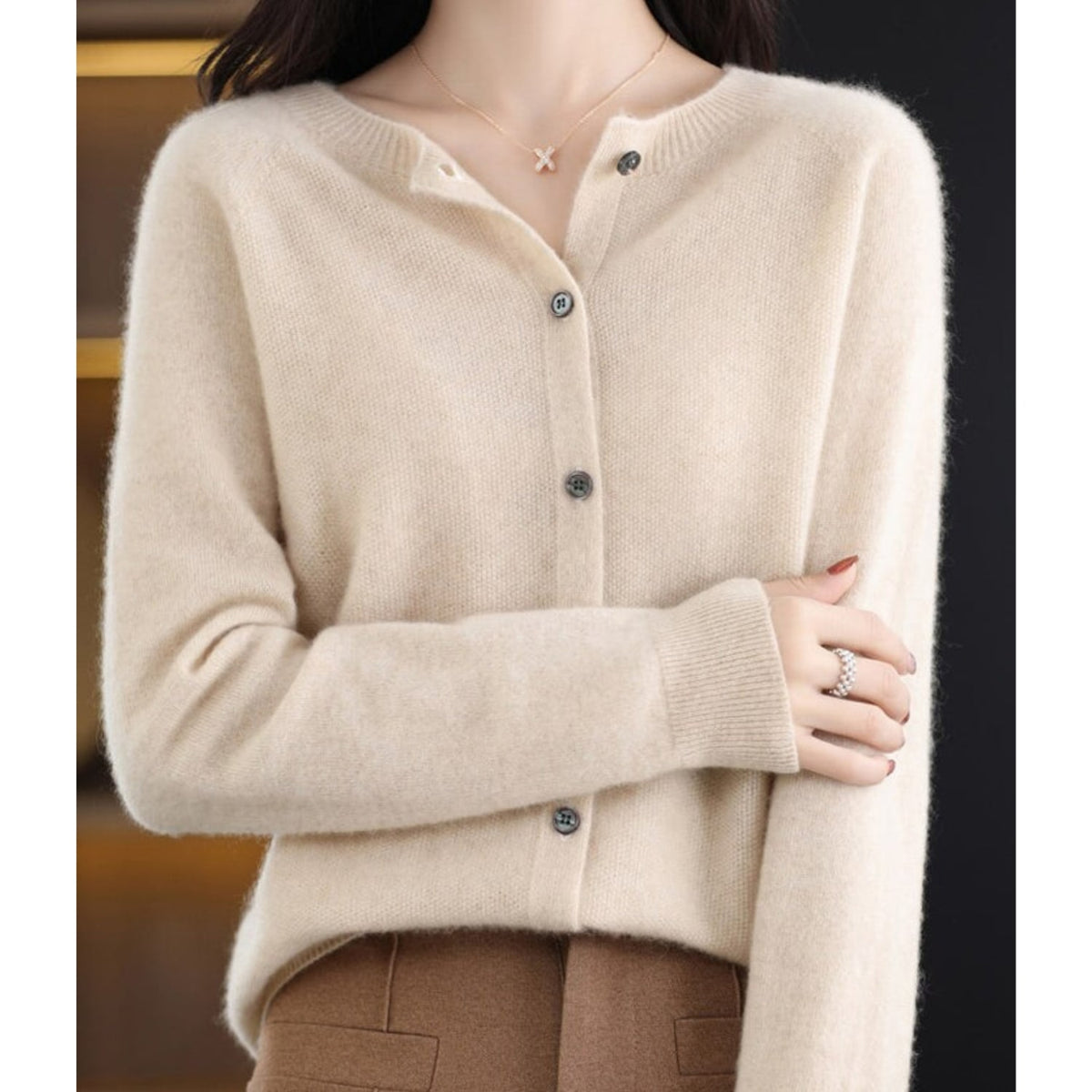 A model wears an off-white button-up cardigan.