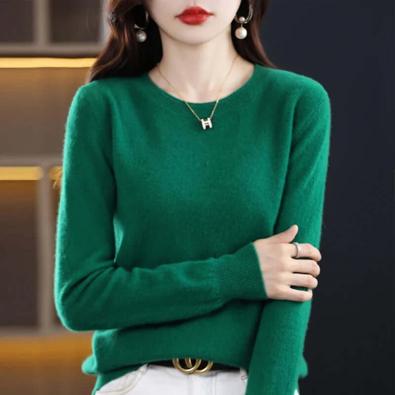 Front view of a woman wearing a green fine-knit crew neck sweater.