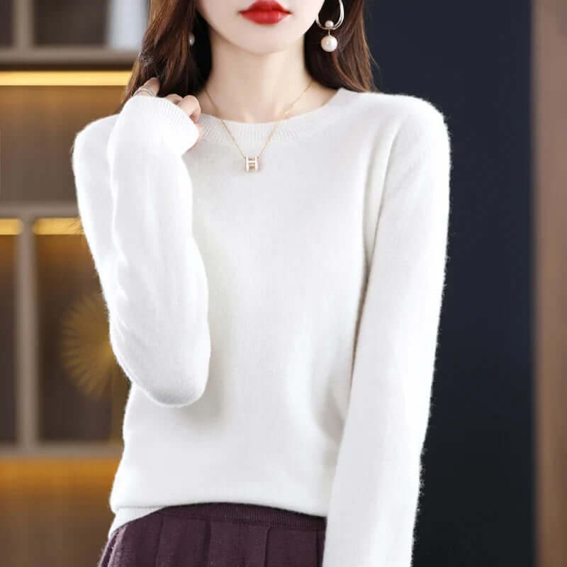 Front view of a woman wearing a white fine-knit crew neck sweater.