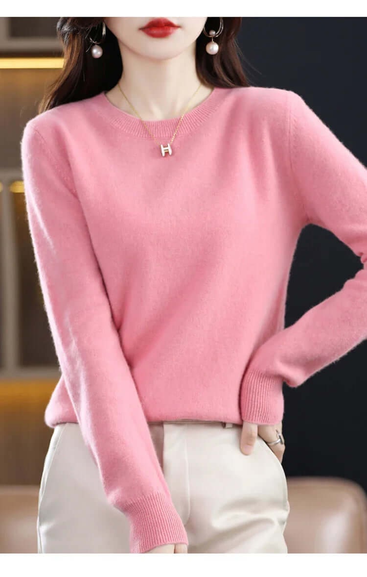 Front view of a woman wearing a pink fine-knit crew neck sweater.