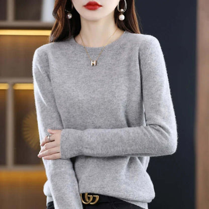 A model wearing a light gray long-sleeved crew neck sweater.