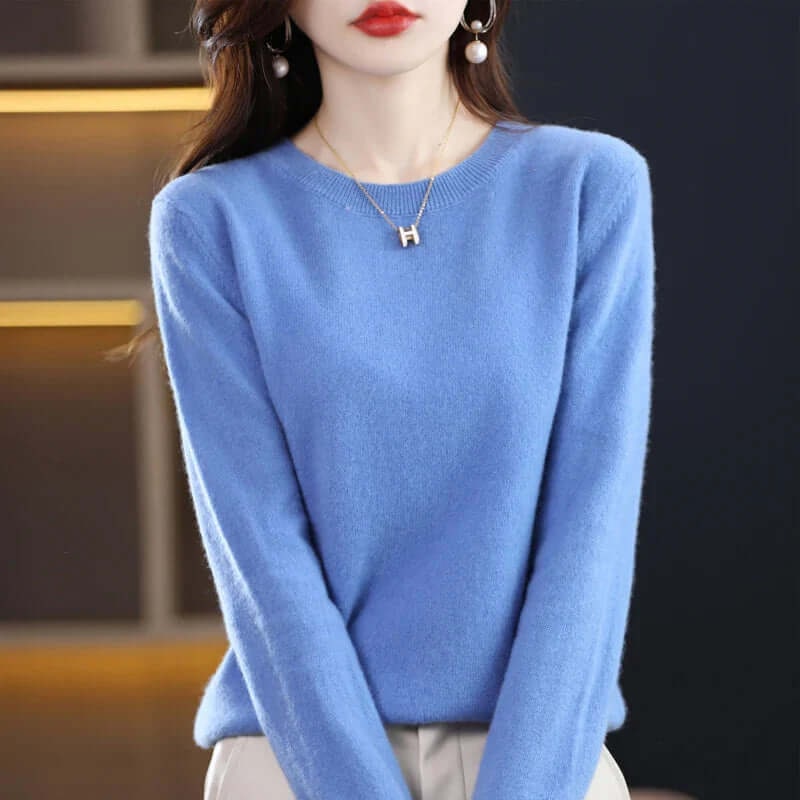 A model wearing a blue long-sleeved crew neck sweater.