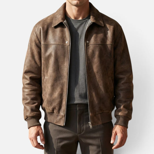 Front view of a man wearing a brown faux suede bomber jacket over a grey t-shirt and dark trousers.