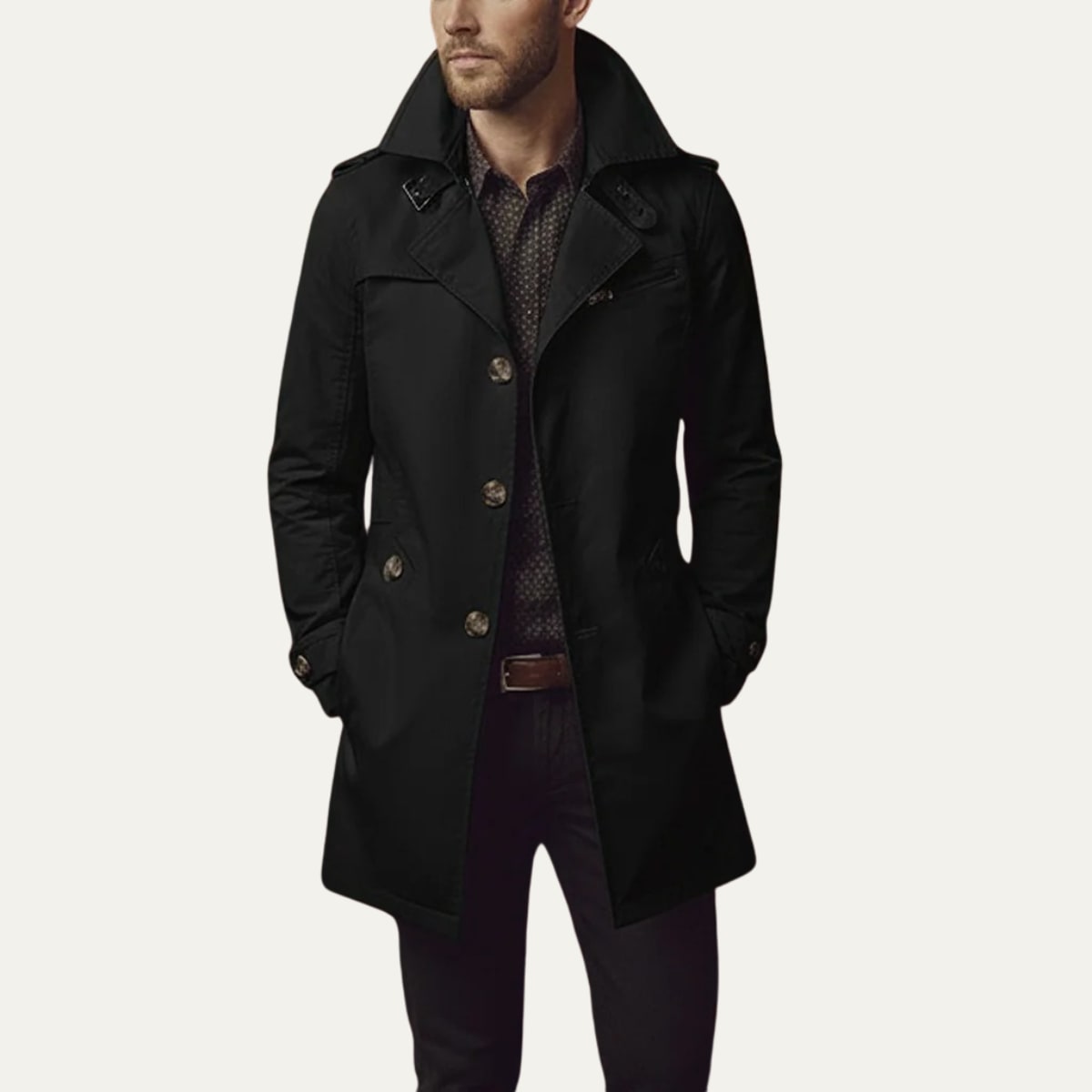 Front view of a man wearing a black single-breasted trench coat with a patterned shirt and dark trousers.