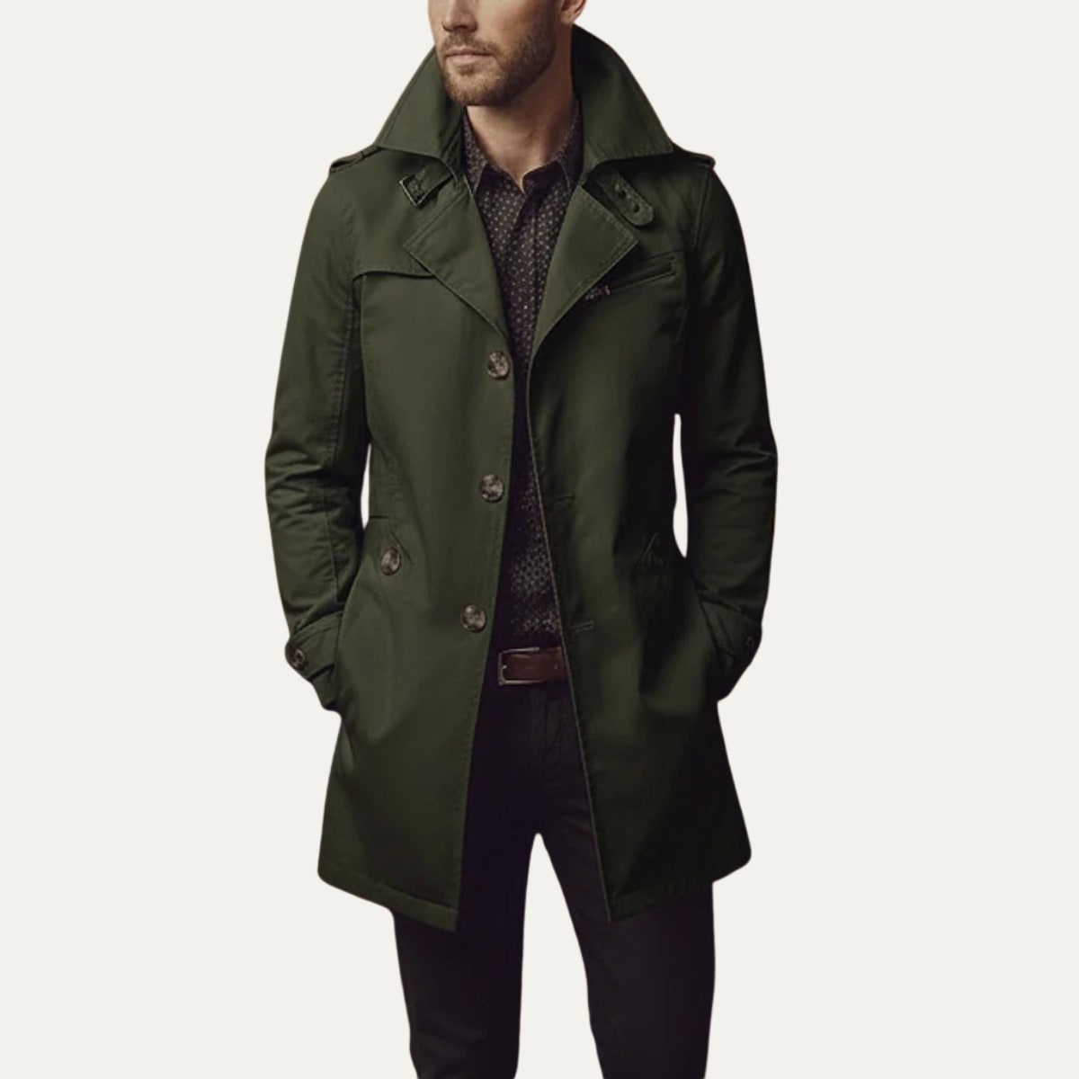 Front view of a man wearing a dark green single-breasted trench coat with a patterned shirt and dark trousers.