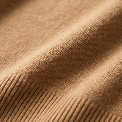 Close-up detail of the camel-colored cashmere fabric and ribbed texture of the sweater.
