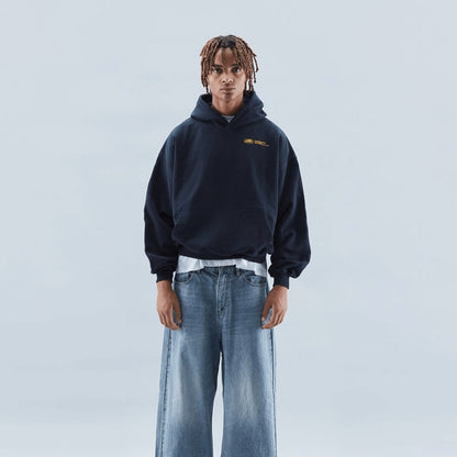 On-model front view of a dark blue oversized hoodie, worn with light wash baggy jeans.